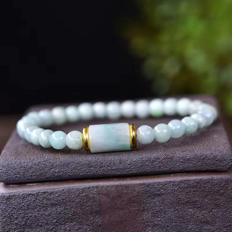 Close-up of a natural emerald green Myanmar jade stone bracelet with round lucky beads on a wrist.
