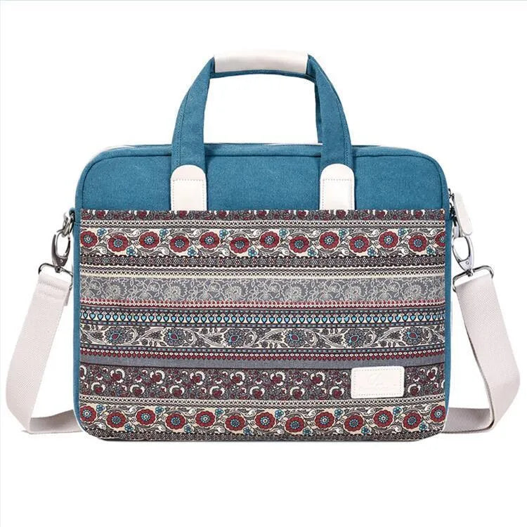 Ethnic style canvas laptop bag in lake blue with zippered front pocket on a table