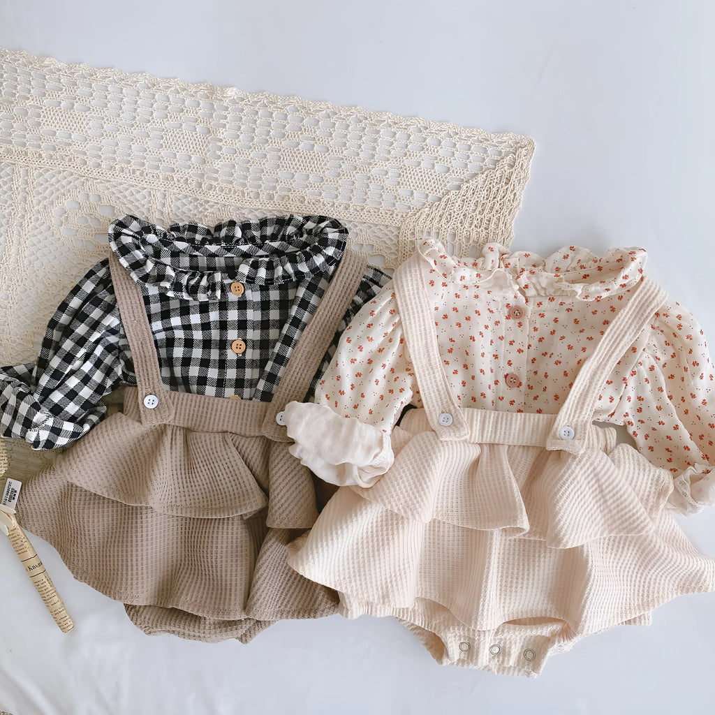 Baby girl wearing a pleated lotus leaf design cotton romper in a triangle climb style.
