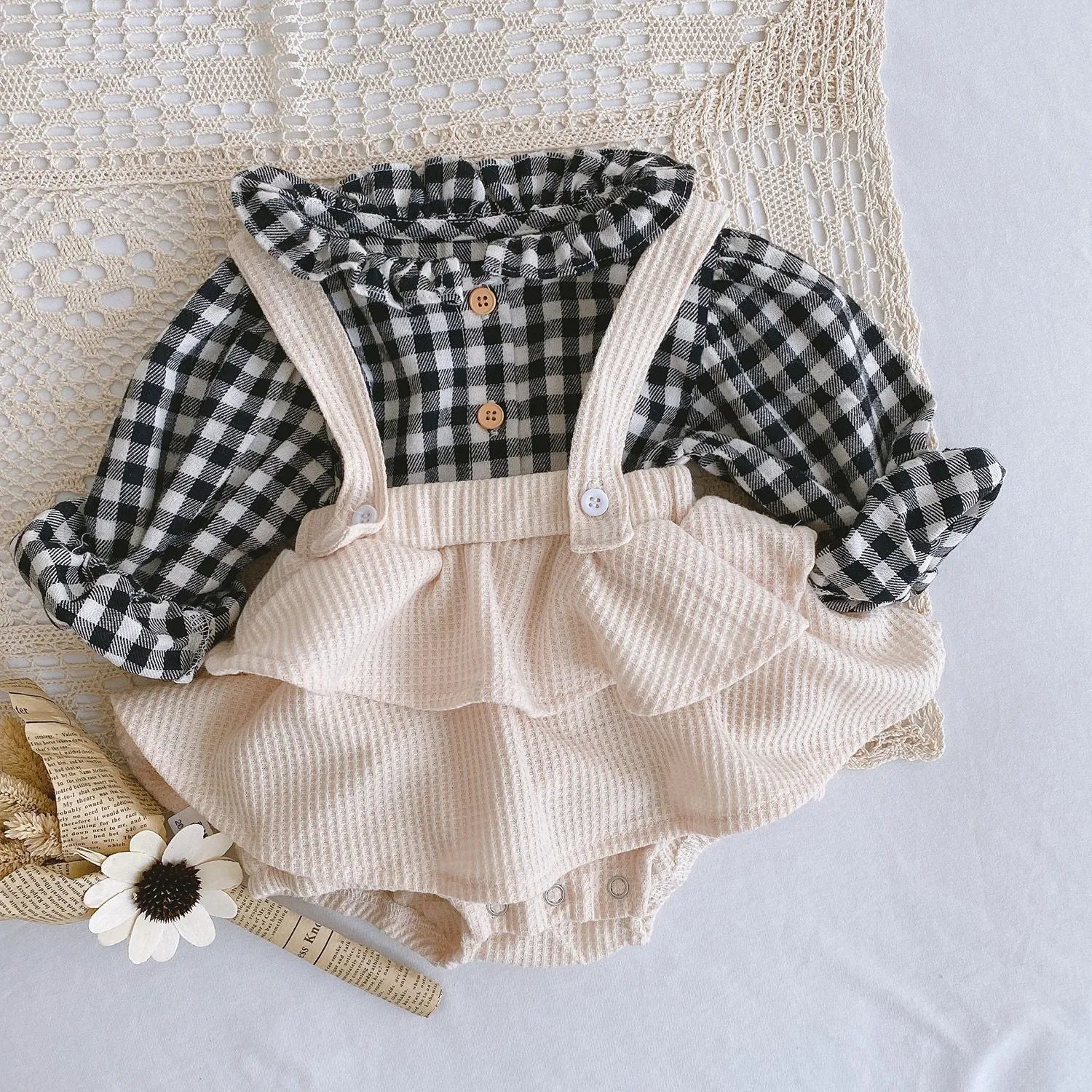 Baby girl wearing a pleated lotus leaf design cotton romper in a triangle climb style.