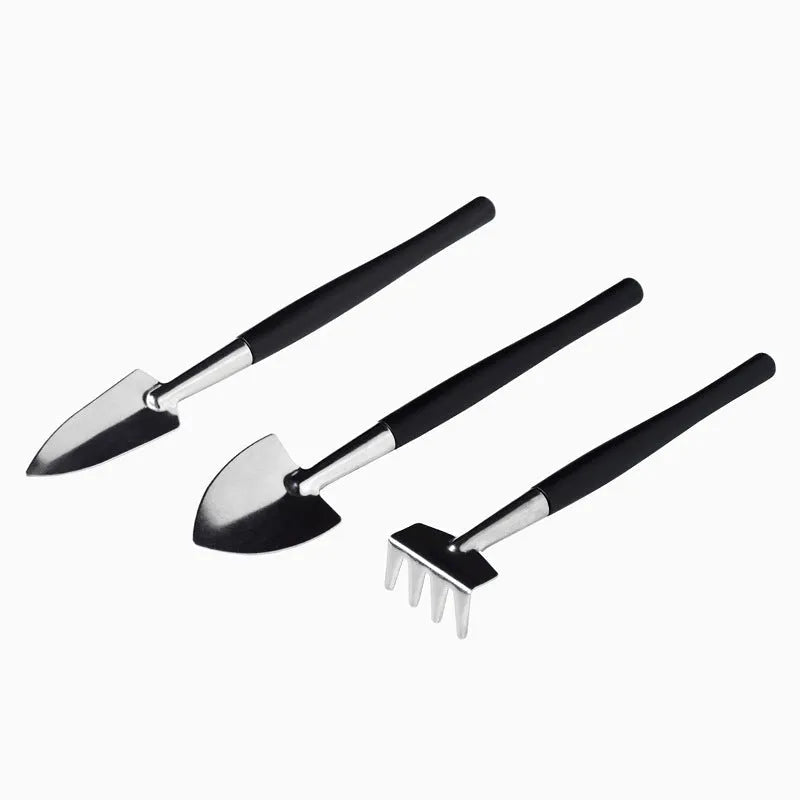 Black plastic and metal mini garden tool set with 16 pieces including tweezers, shovels, brushes, bottles, and a square work cushion for succulent care.
