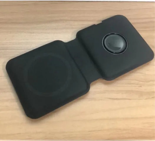 White foldable magnetic wireless charging dock with a phone attached and earbud case on the base.