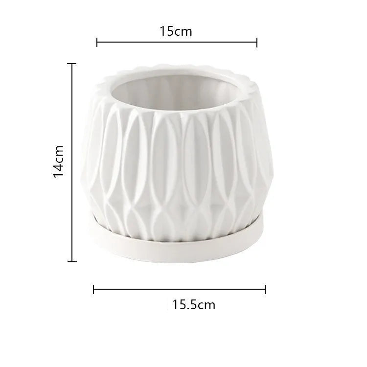 Grey small ceramic tabletop plant flowerpot on a desktop with a small green plant