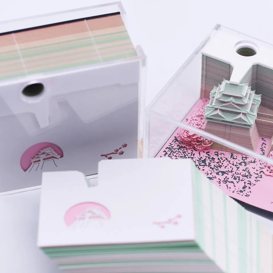 3D paper architectural model of the Tianshou Tower from Spirited Away, shown in gold, pink, and white colour options.