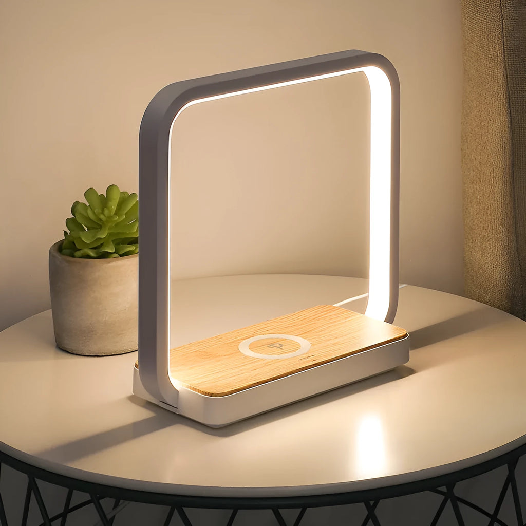 Modern white smart bedside lamp with touch control and USB cable on a wooden nightstand.