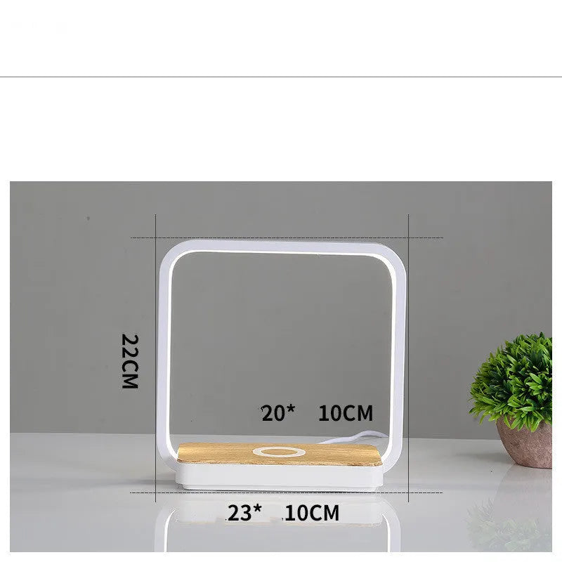 Modern white smart bedside lamp with touch control and USB cable on a wooden nightstand.