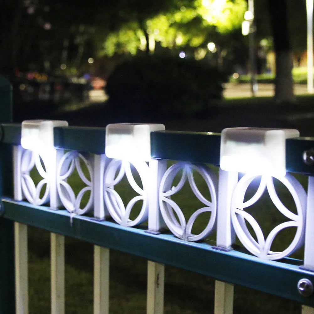 White solar-powered railing light with LED illumination for outdoor steps and garden fencing