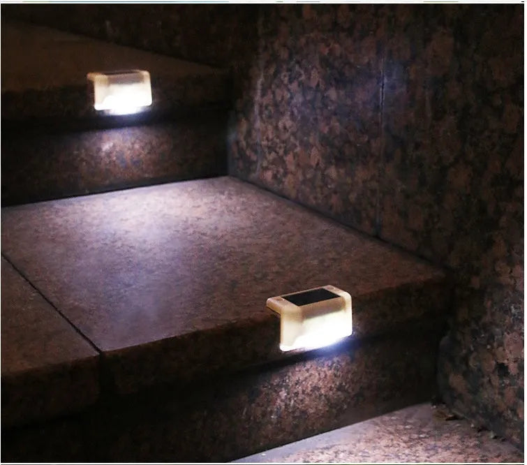 White solar-powered railing light with LED illumination for outdoor steps and garden fencing