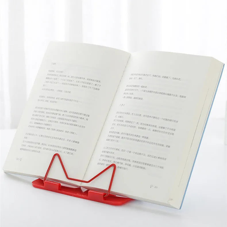Red reading frame holding a book upright at an angle on a desk
