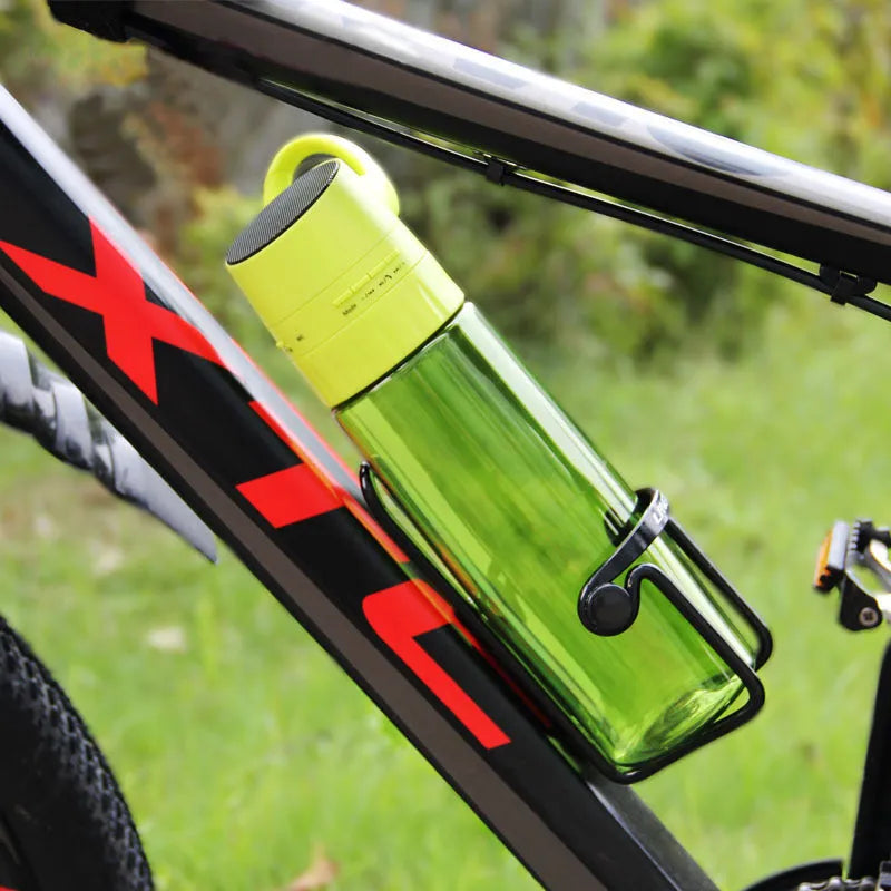 750ml orange PC plastic cycling water bottle with integrated Bluetooth audio speaker on outdoor background