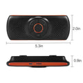 Orange plastic Bluetooth hands-free car speaker kit mounted on a sun visor.