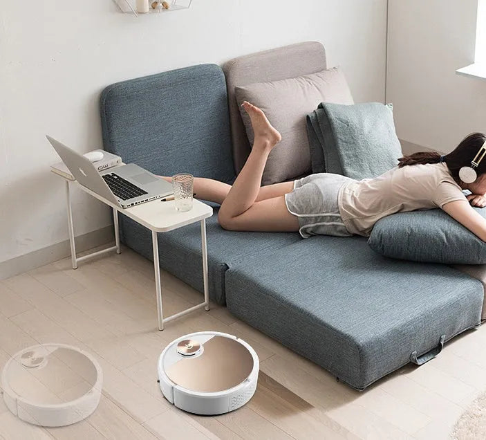 Golden robotic vacuum cleaner with remote control on hardwood floor