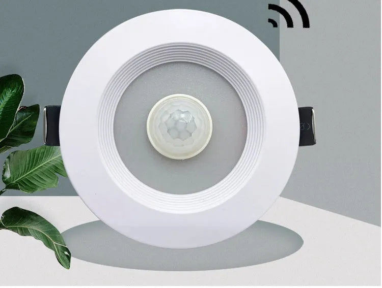 Aluminium infrared body sensing LED downlight with white light, shown in a ceiling recess.