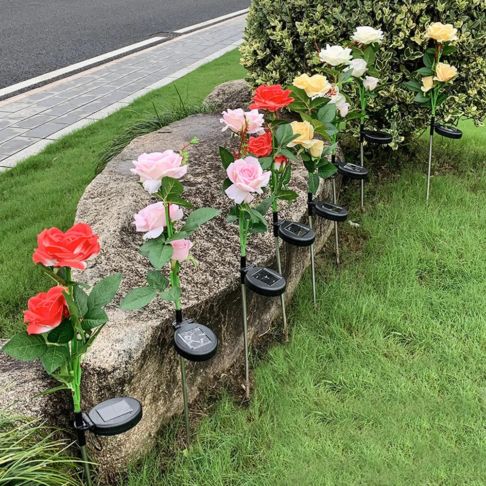 Outdoor solar rose lawn lamp with three rose heads, ground spike installation, and silk cloth petals