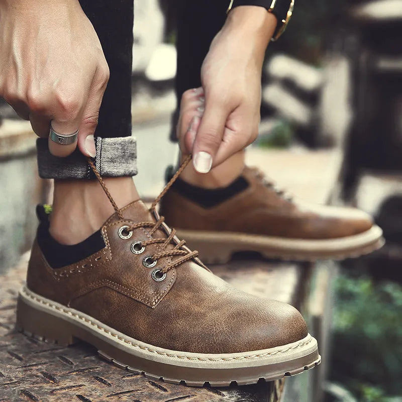 Men's brown round-toe casual shoes with front-tie laces and a low-profile rubber sole on a plain background.