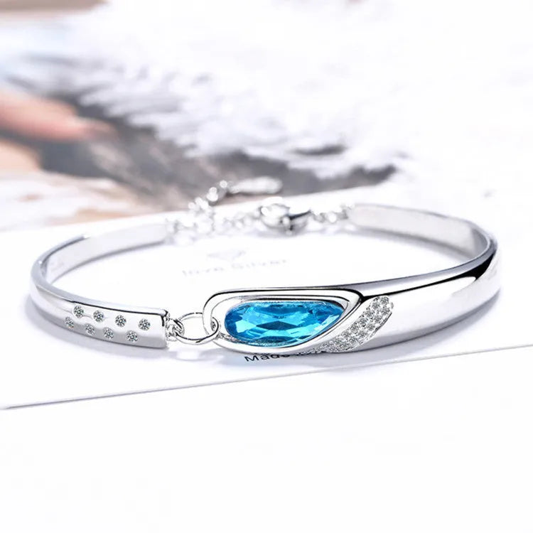 Silver-plated heart pendant necklace with blue crystal zircon inlay on display
