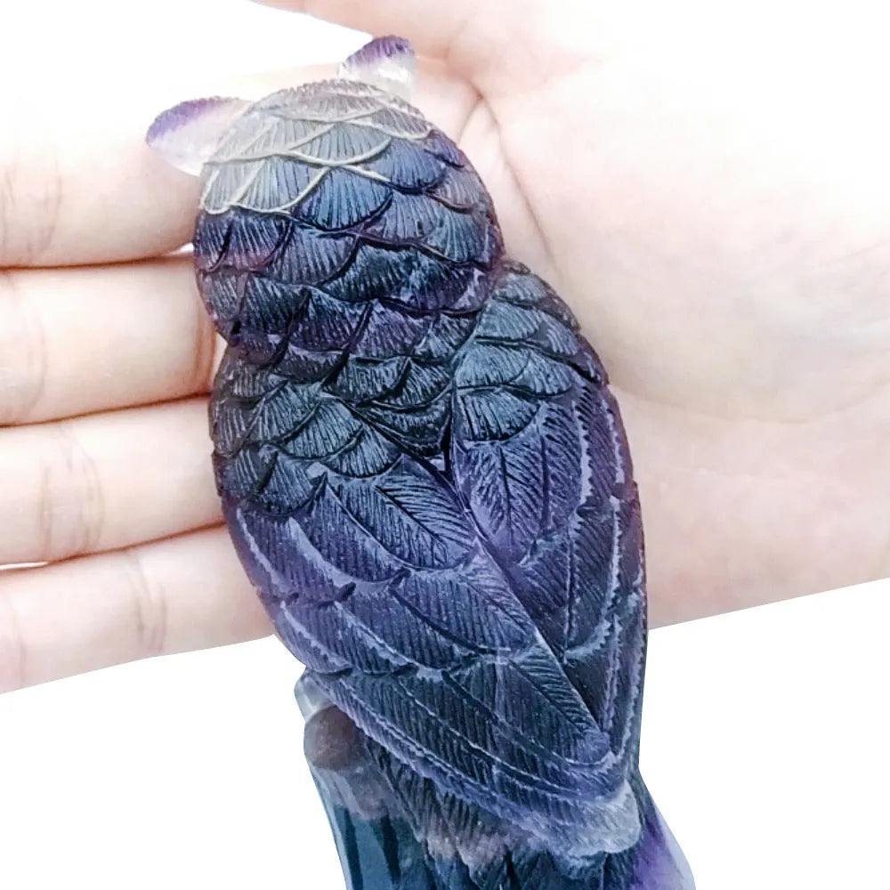 Hand carved purple fluorite owl ornament showing detailed carving and natural colour variation