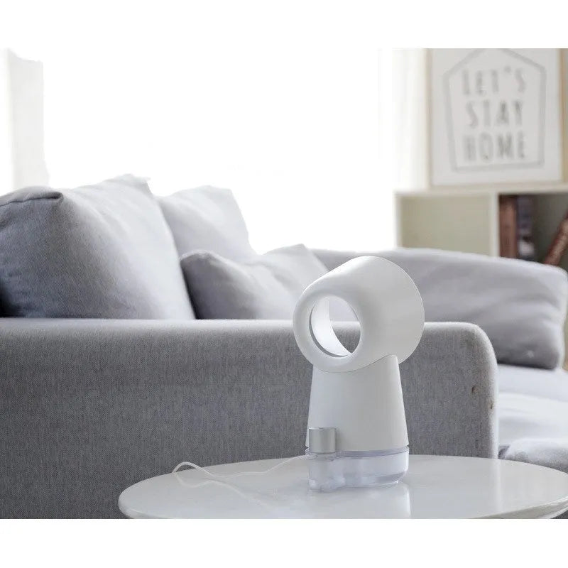 White desktop humidifier with leafless fan and 300ML water tank on a desk, emitting cool mist from single fog outlet