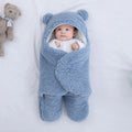 Cotton blend baby quilted sleeping bag wrapper in light blue, shown flat with size label.