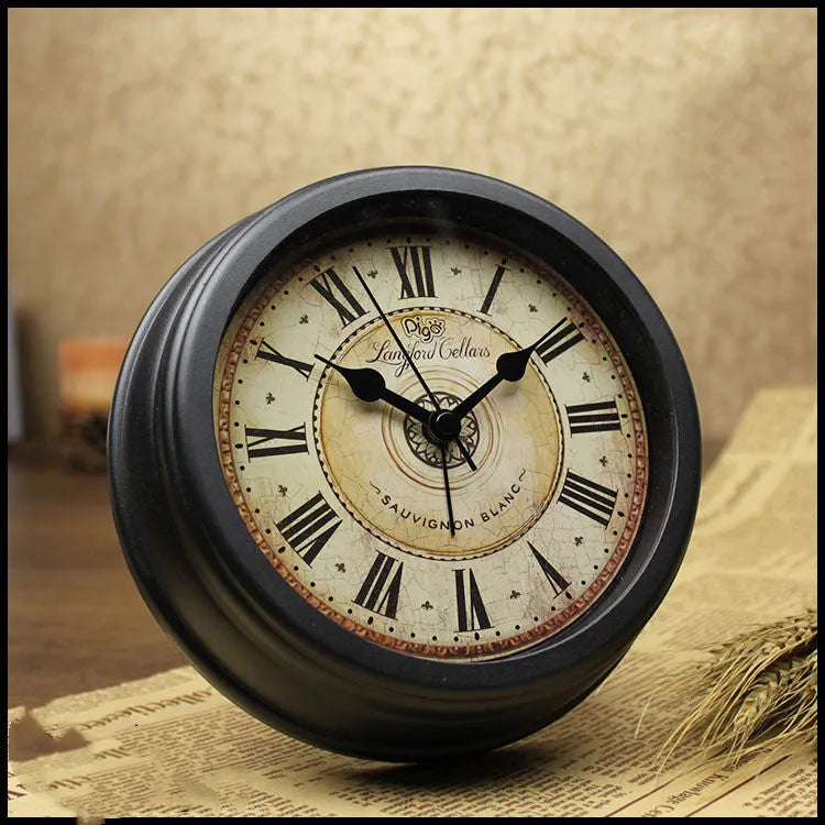 Round retro-style desk alarm clock with a white dial and silent sweep movement on a wooden surface.