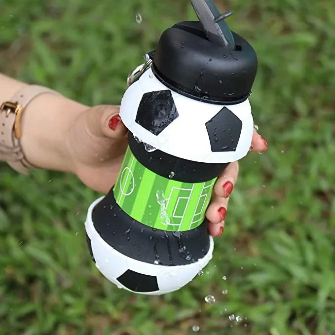 White collapsible silicone soccer water bottle with straw and carrying clip on white background