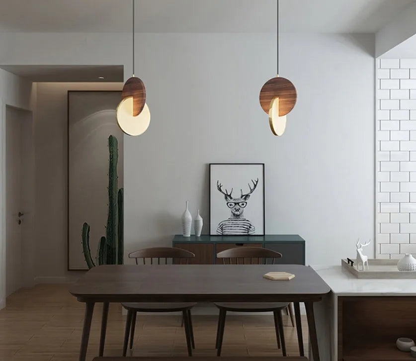 Long-line modern chandelier made from carved solid walnut wood, mounted on a wall, emitting warm white light.