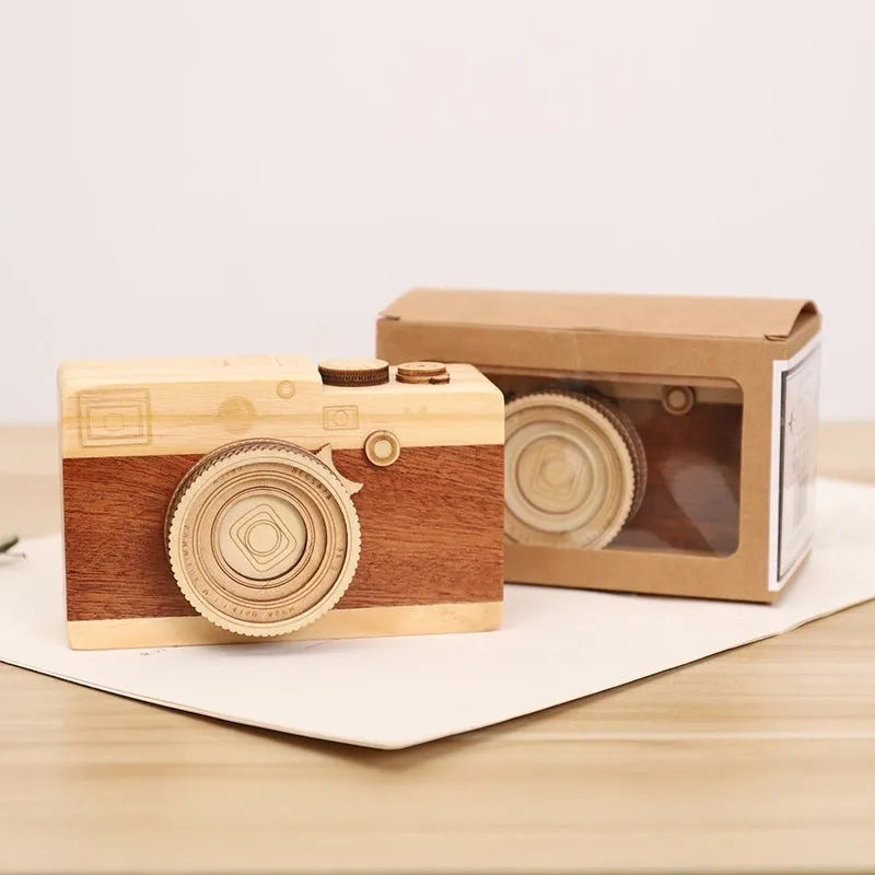 Pine wood camera-shaped rotating music box in decorative gift packaging.