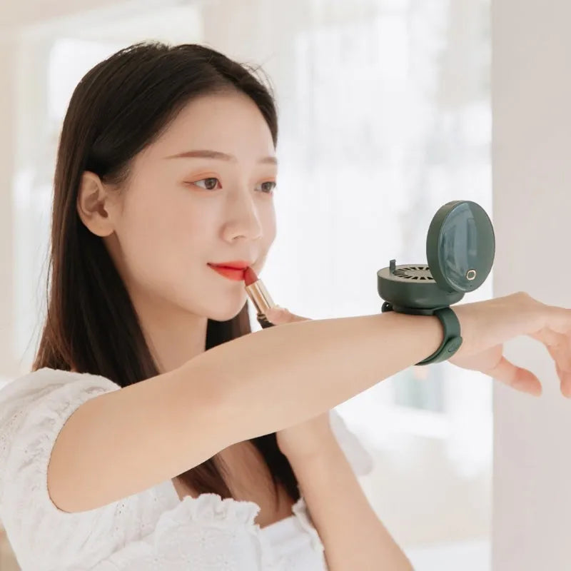 Portable leafless wrist fan with mirror, USB rechargeable, three speed settings, 66x41mm, in white on a table