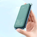 Mint green Maiduo MagSafe magnetic wireless power bank attached to the back of an iPhone