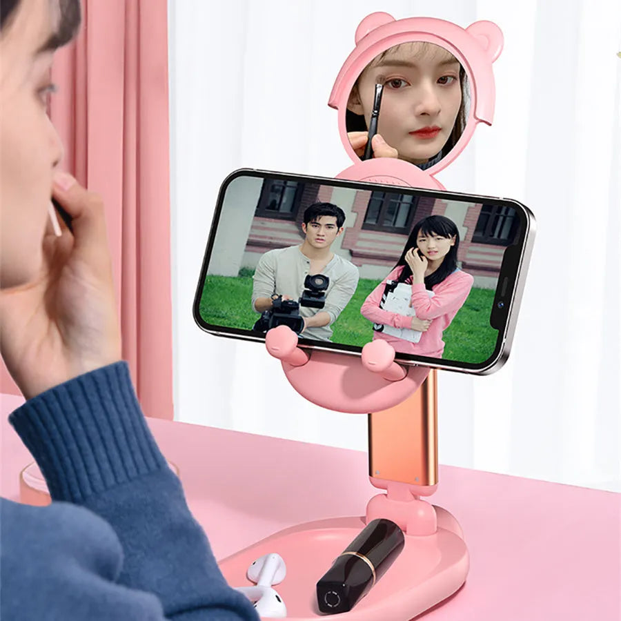 Blue foldable mobile phone holder with mirror holding an iPhone on a desk
