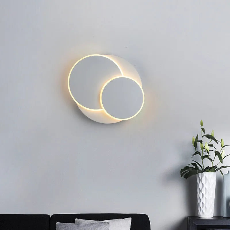 Modern round acrylic wall lamp in black and white, shown in small, medium, and large sizes.