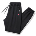 Pair of 95% cotton drawstring trousers in light grey, straight-leg nine-tenths length, laid flat on a plain background