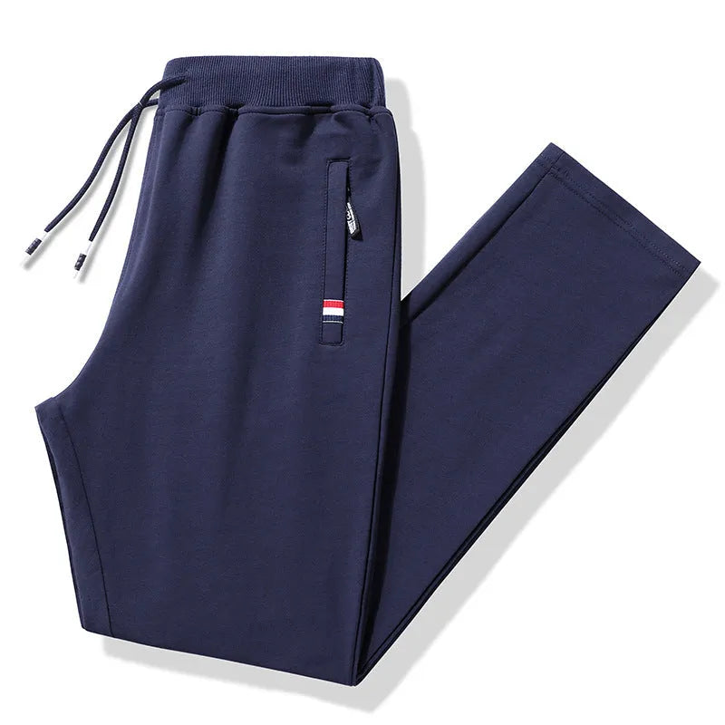 Pair of 95% cotton drawstring trousers in light grey, straight-leg nine-tenths length, laid flat on a plain background