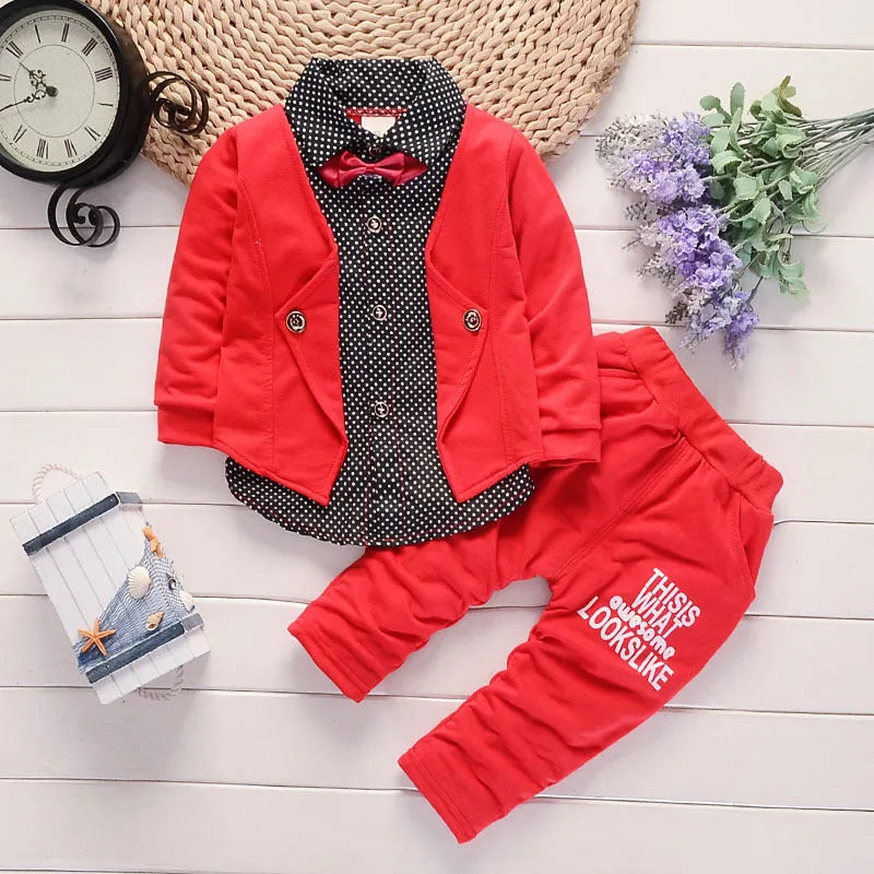 Toddler boy wearing a grey printed casual suit set with jacket and trousers.
