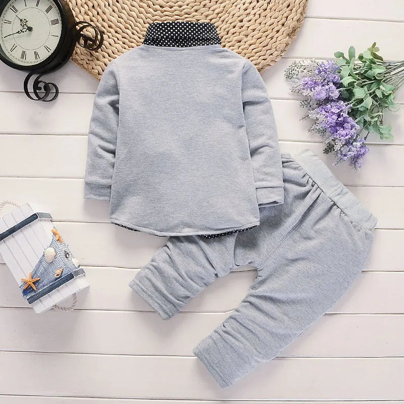 Toddler boy wearing a grey printed casual suit set with jacket and trousers.