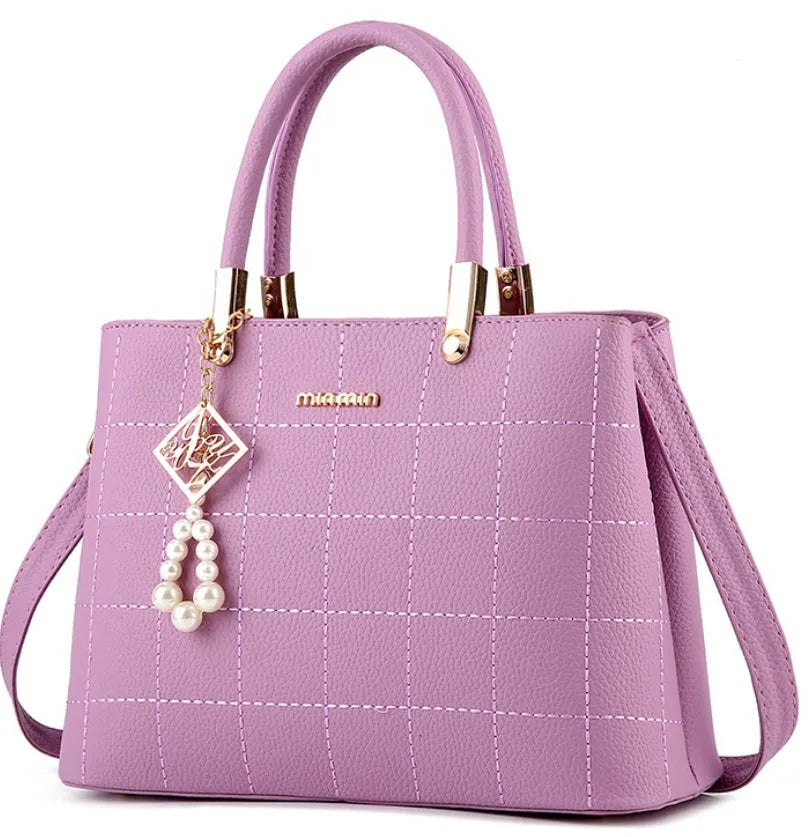 Medium women's PU handbag with zip top, soft handle, car suture detail, and horizontal square shape