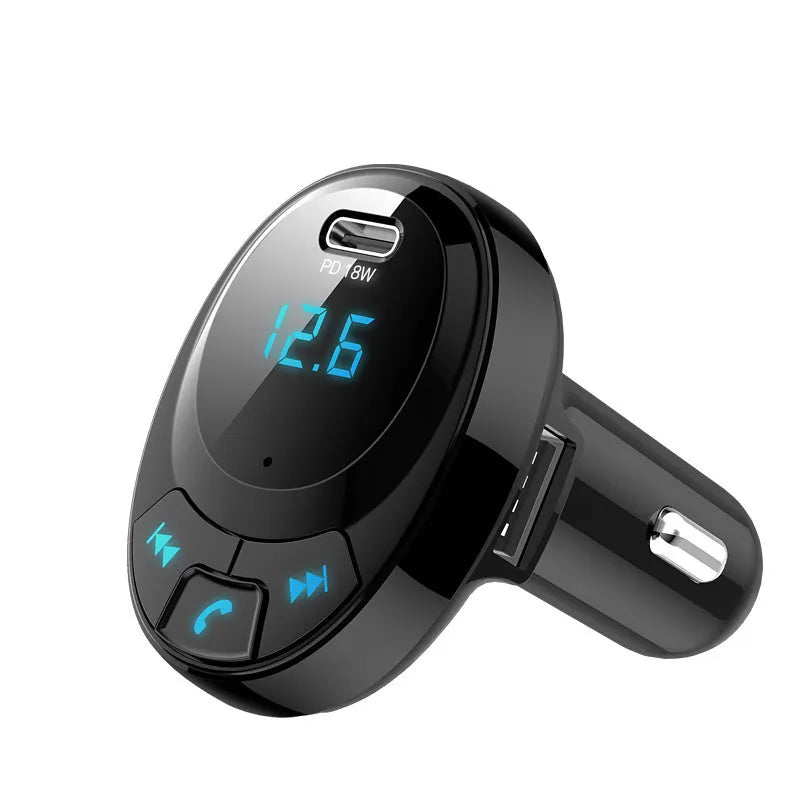 Black Bluetooth car MP3 charger with numeric display plugged into a car dashboard cigarette lighter.