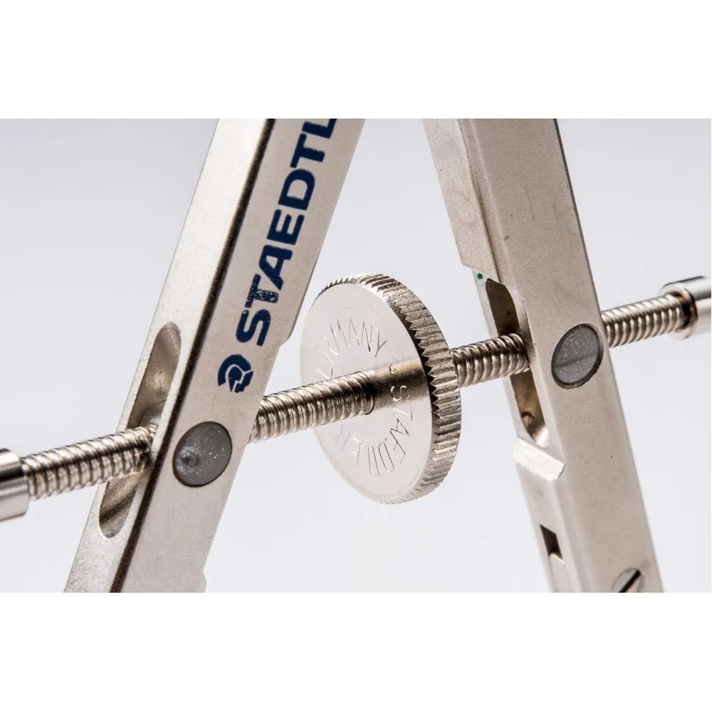 STAEDTLER 551 01 steel precision car compass for technical drawing on a drafting table.