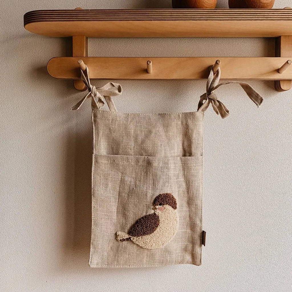 Khaki coloured cotton linen hanging storage bag with one pocket, designed for bedside organisation.