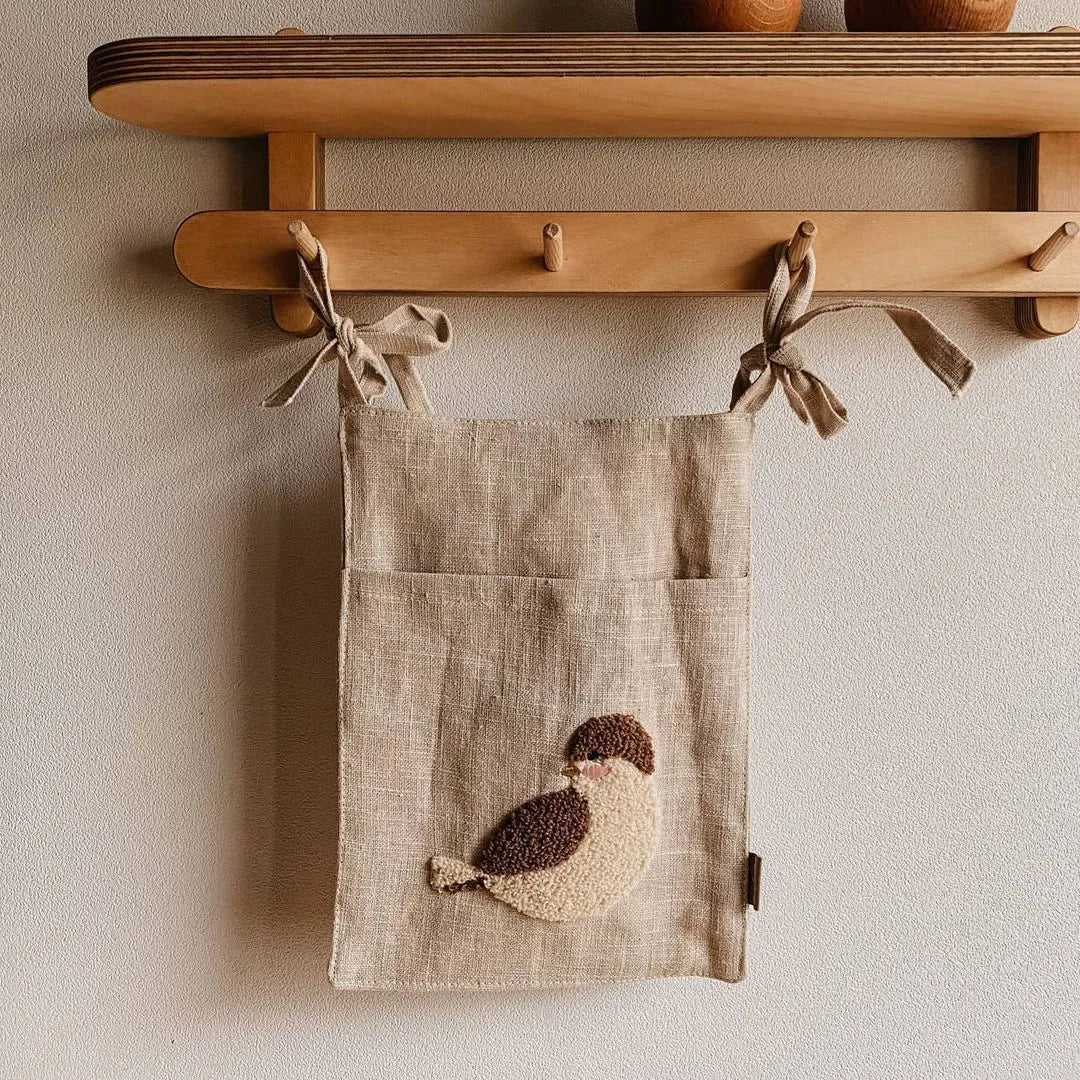 Khaki coloured cotton linen hanging storage bag with one pocket, designed for bedside organisation.