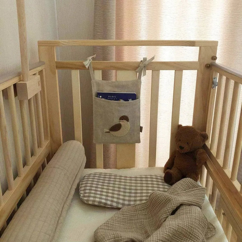 Khaki coloured cotton linen hanging storage bag with one pocket, designed for bedside organisation.