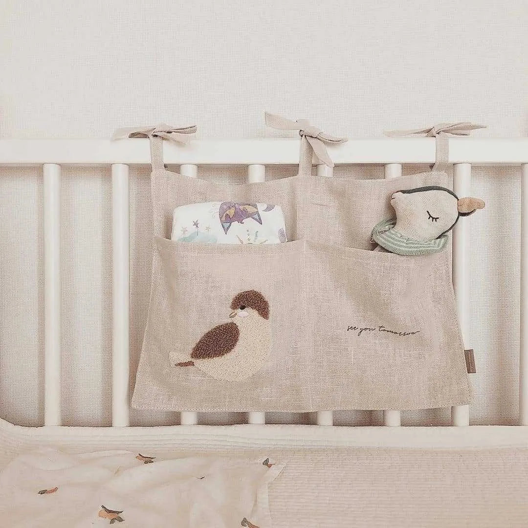 Khaki coloured cotton linen hanging storage bag with one pocket, designed for bedside organisation.