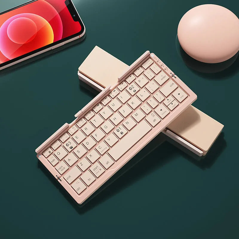 Silver white folding Bluetooth keyboard open with stand holding a smartphone, shown next to its closed compact size.
