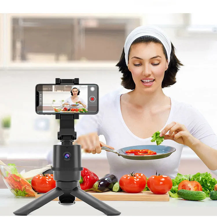 360 degree AI tracking pan tilt smartphone bracket on a table, showing phone holder and rotation base.