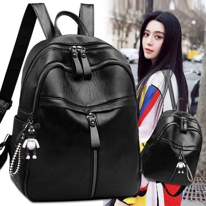 Black PU leather backpack with double straps, shown with and without a decorative pendant.