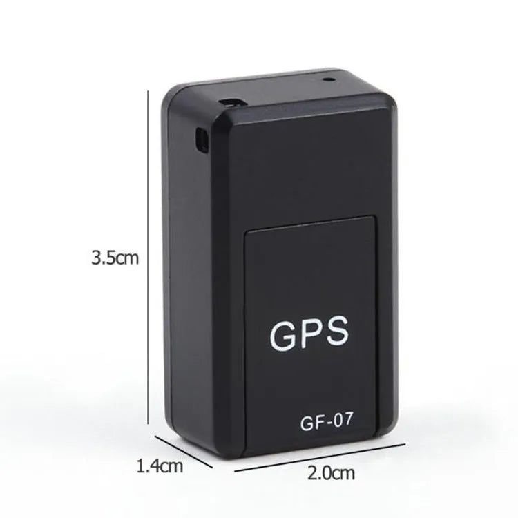 Small black magnetic GPS tracker device next to a micro-USB cable on a table.