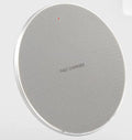 Black aluminum wireless charging pad with phone showing charging indicator light