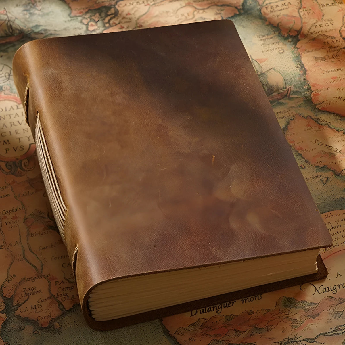 Brown handmade cowhide leather notebook with 200 pages, 19x14cm paper size, lying open on a wooden desk