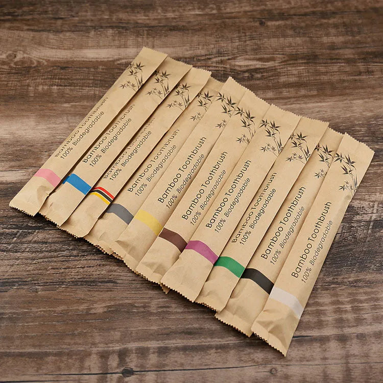 10 multi-coloured natural bamboo toothbrushes with soft charcoal bristles arranged on a white background