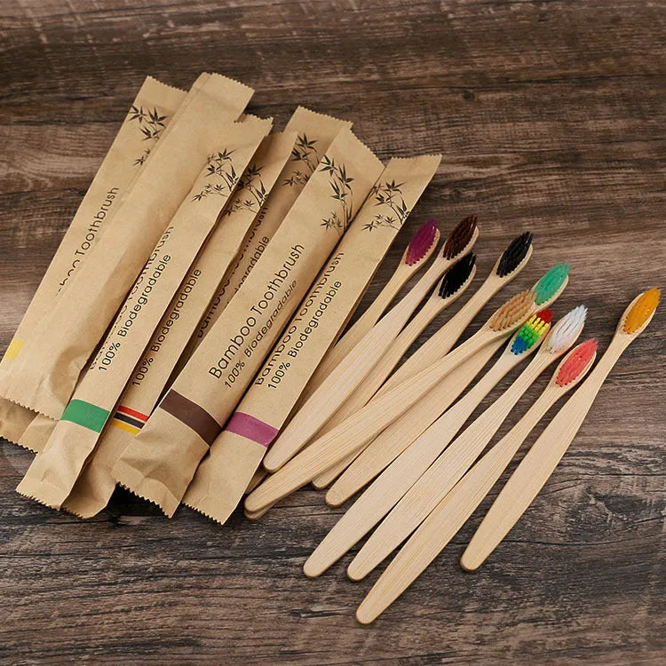 10 multi-coloured natural bamboo toothbrushes with soft charcoal bristles arranged on a white background